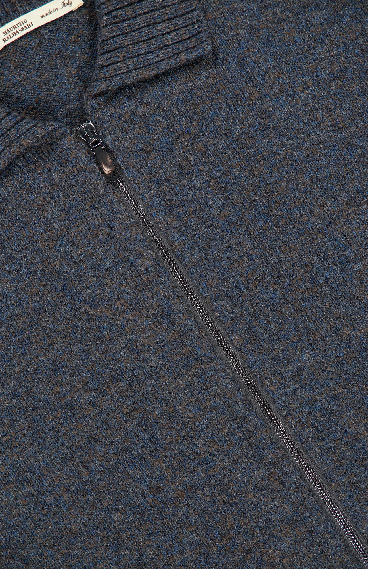 Close-up of a blue and brown mottled Maurizio Baldassari Mouline Zipped Knit Overshirt in virgin wool, featuring a zip-up front and a ribbed collar.