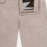 The image features the MAURIZIO BALDASSARI Treves Five Pocket Corduroy Pants in light beige, expertly crafted in Italy. The pants are displayed with the zipper and top button undone to reveal the inner waistband and pocket lining, highlighting the fabric’s distinctive vertical ribbed texture.
