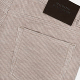 Close-up of the MAURIZIO BALDASSARI Treves Five Pocket Corduroy Pants in taupe, made in Italy, featuring a back pocket and a dark rectangular leather patch near the waistband. The corduroy fabric showcases distinctive vertical ridges.