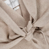A close-up of a beige MAX MARA Long Cashmere Jacket with Bonus Scarf, made in Italy, featuring a tied knot detail at the front. The MAX MARA label is visible inside the collar.