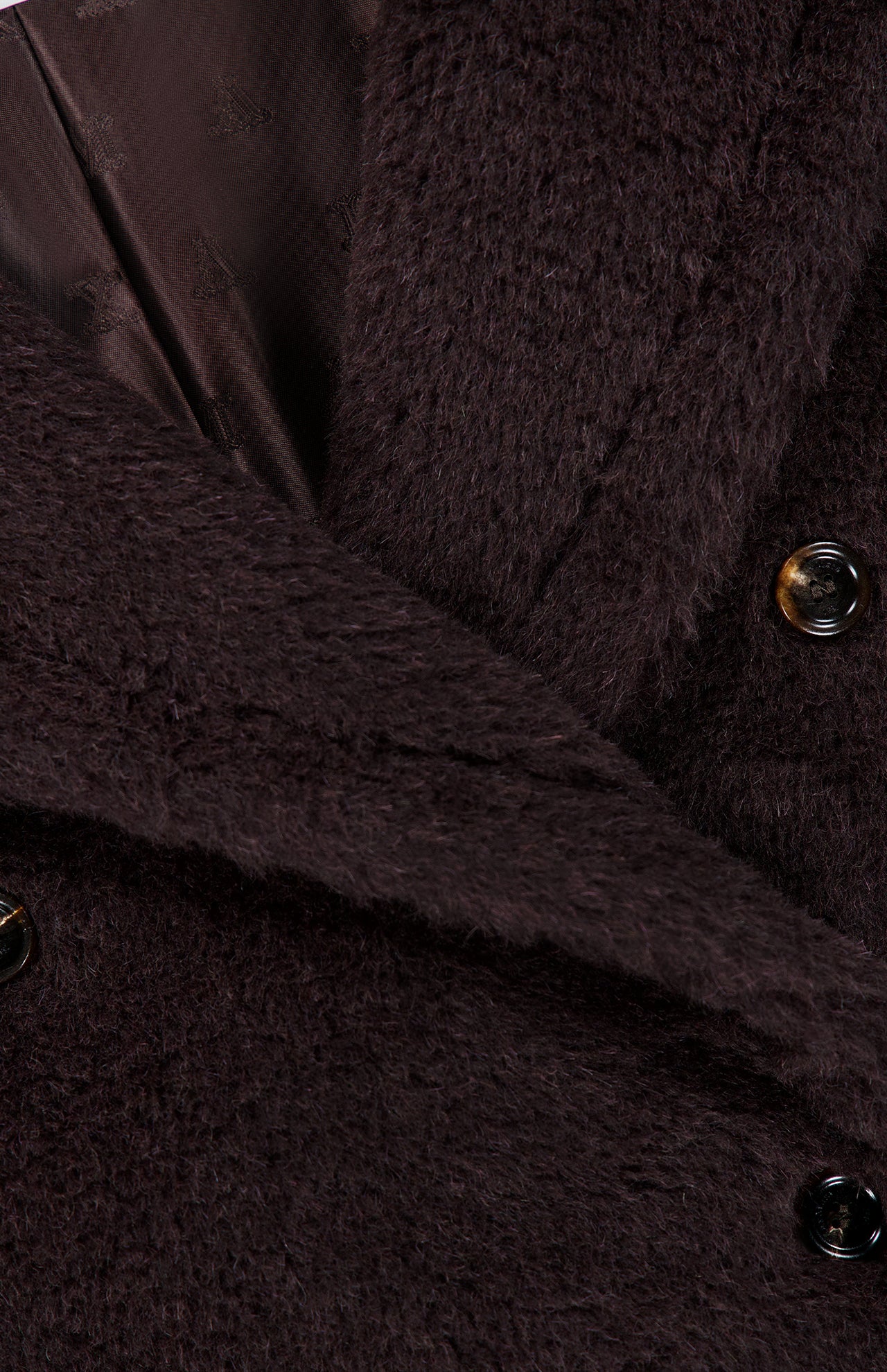 Close-up of a dark brown Max Mara Teddy Short Coat with a fuzzy texture, featuring dark horn buttons and a smooth, logo-patterned lining.