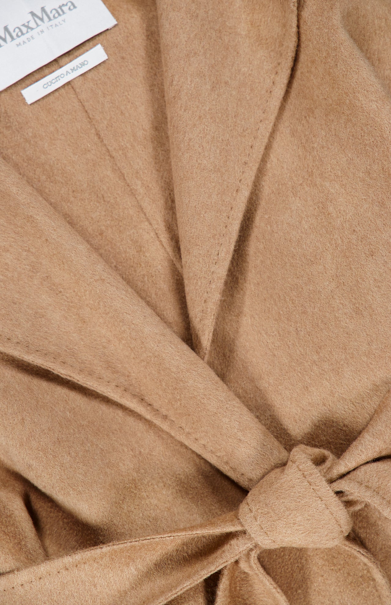Close-up of a camel-colored MAX MARA Wrap Trench Coat with a belted wrap design and notched lapels.