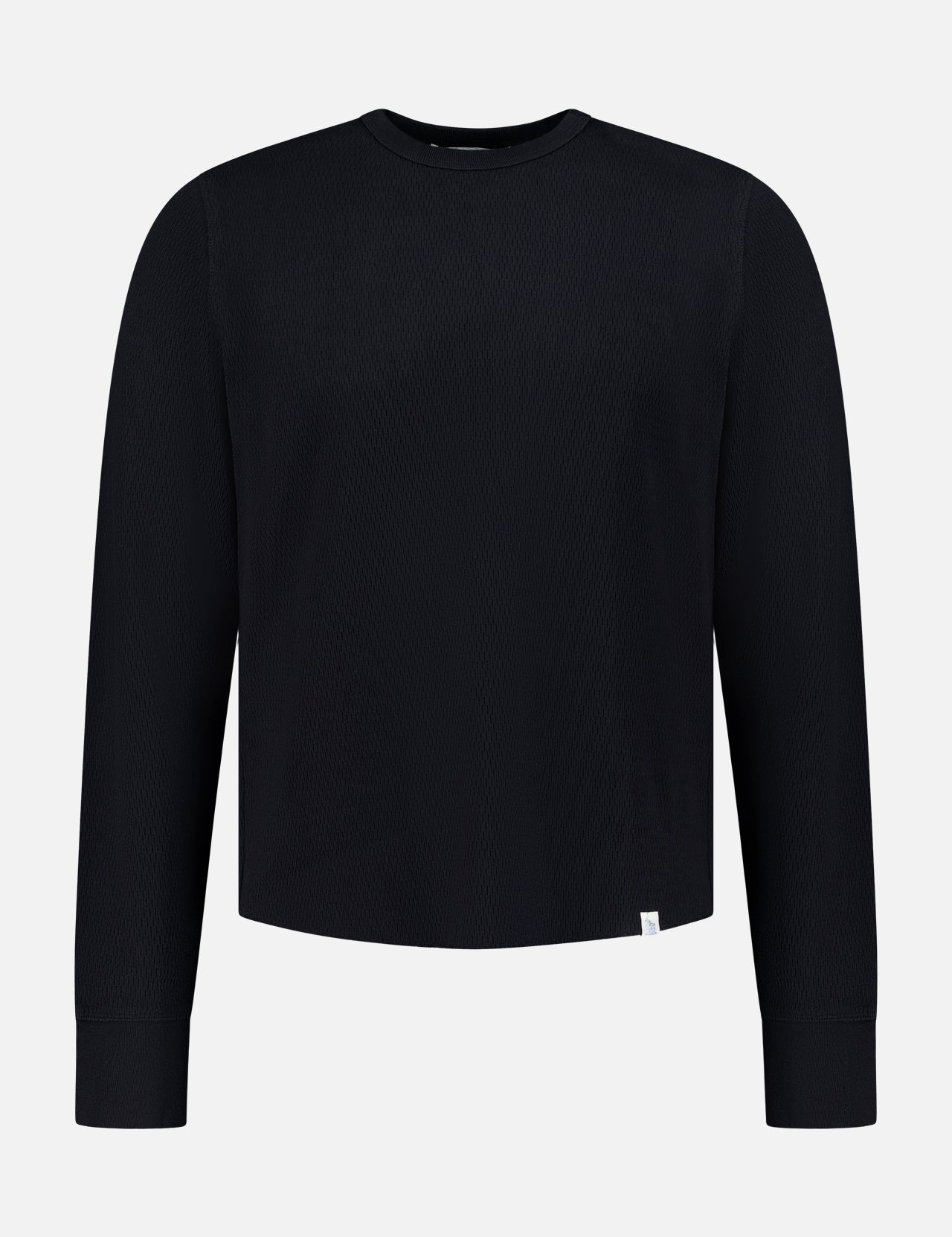A Merz B. Schwanen Cotton Thermal Long Sleeve T-shirt is displayed on a plain white background. Made from organic cotton, this black crewneck shirt features a minimalist design with long sleeves and is accented by a small white tag near the bottom hem.
