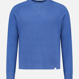 The Merz B. Schwanen Light Weight Crewneck Sweatshirt is a plain, long-sleeved blue top in soft organic cotton, shown on a white background.