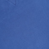 A close-up of the Merz B. Schwanen Light Weight Crewneck Sweatshirt in blue, made from organic cotton, features a ribbed collar, V-stitch detail, and part of a white tag with text.