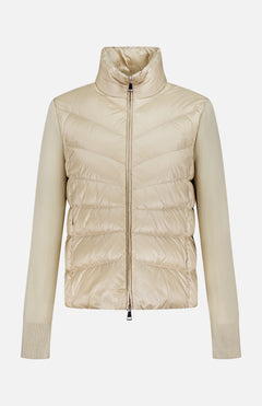 The MONCLER Down-filled Cardigan Jacket features a beige quilted body, high collar, front zipper, knit sleeves, and ribbed cuffs, inspired by the classic cardigan-jacket with a shiny down-filled finish.