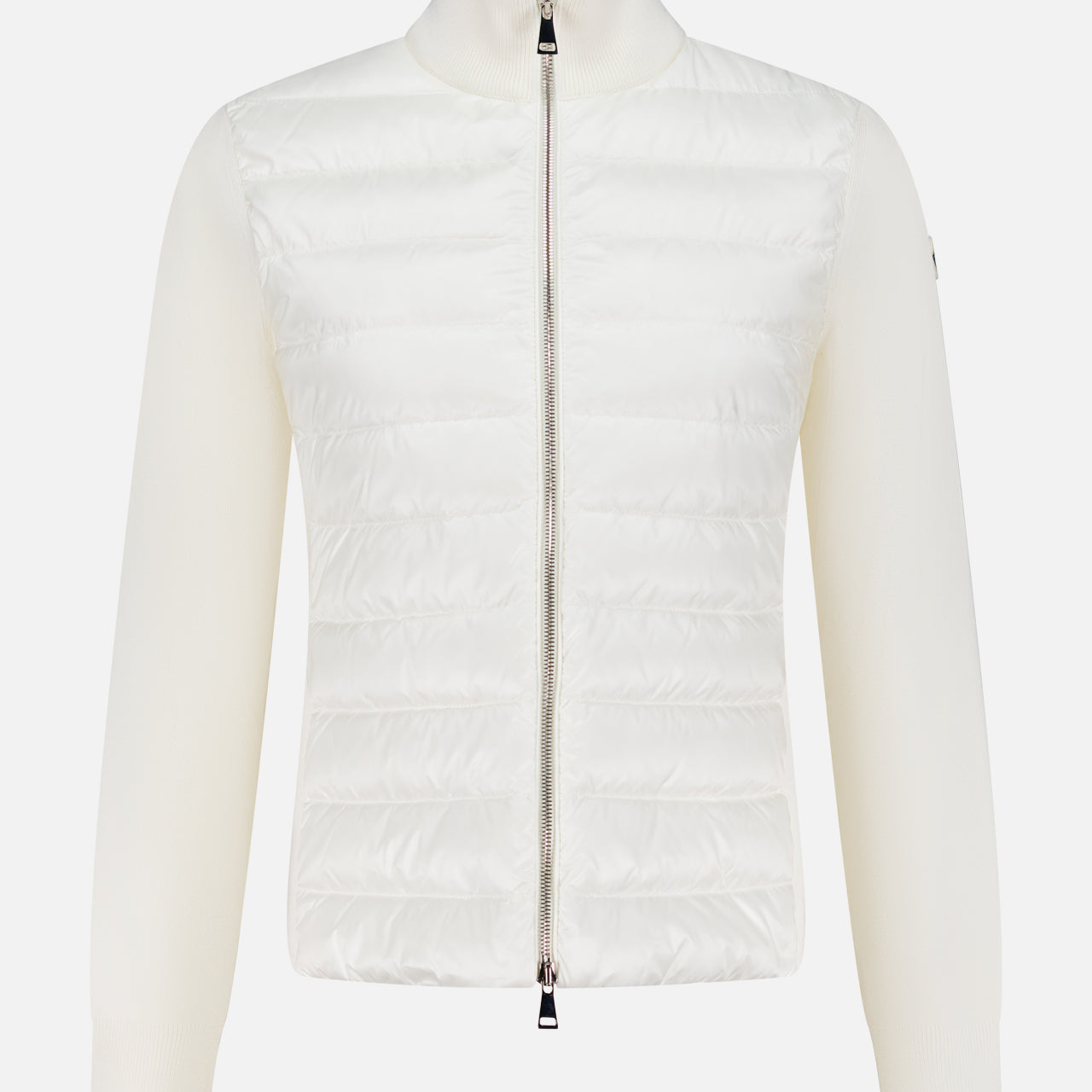 The MONCLER Down Filled Cardigan Jacket is a women’s white knit with a quilted front, ribbed long sleeves, high collar, and a silver zip closure for stylish and chic outerwear.