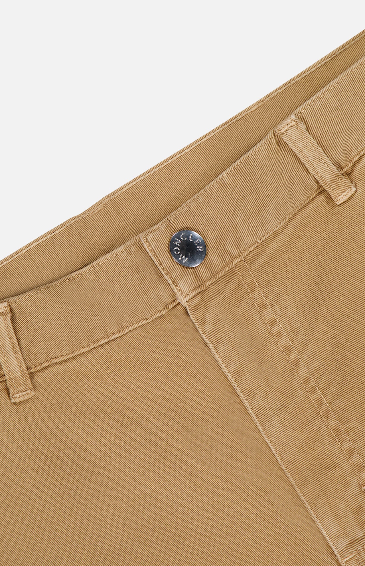 Close-up of MONCLER Stretch Cotton Cargo Trouser Pants in tan, featuring a metal button, belt loop, and visible pocket stitching against a white background.