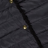 Close-up of the MONCLER Fleurs Bouclé Trim Jacket, featuring a dark quilted texture, water-repellent fabric, three shiny gold buttons, black trim along the front opening, and a partially visible clothing label.