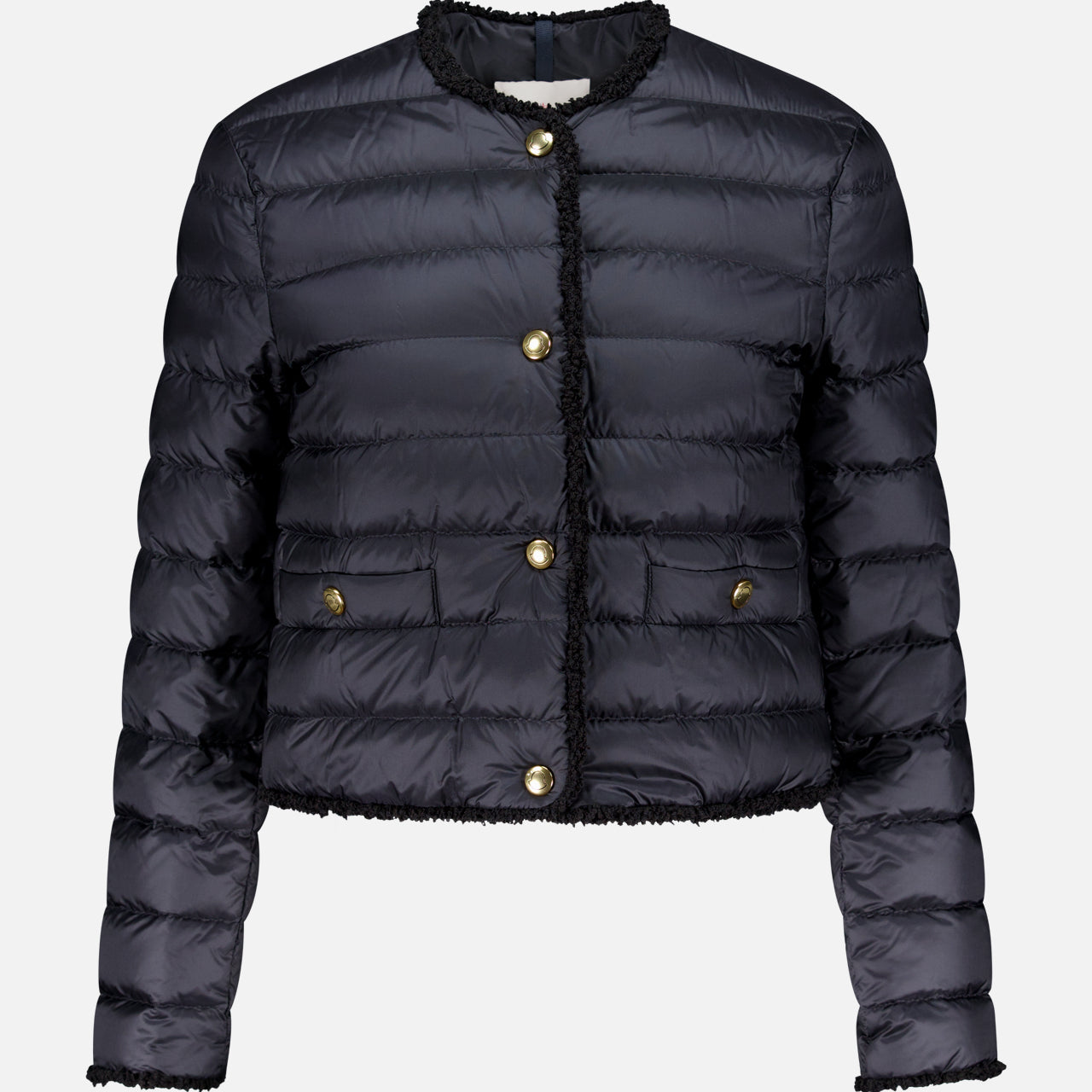 The Fleurs Bouclé Trim Jacket by MONCLER is a black, down-filled, quilted puffer with gold buttons, two front pockets, and no collar. It features long sleeves, is water-repellent, and shown against a plain white background.
