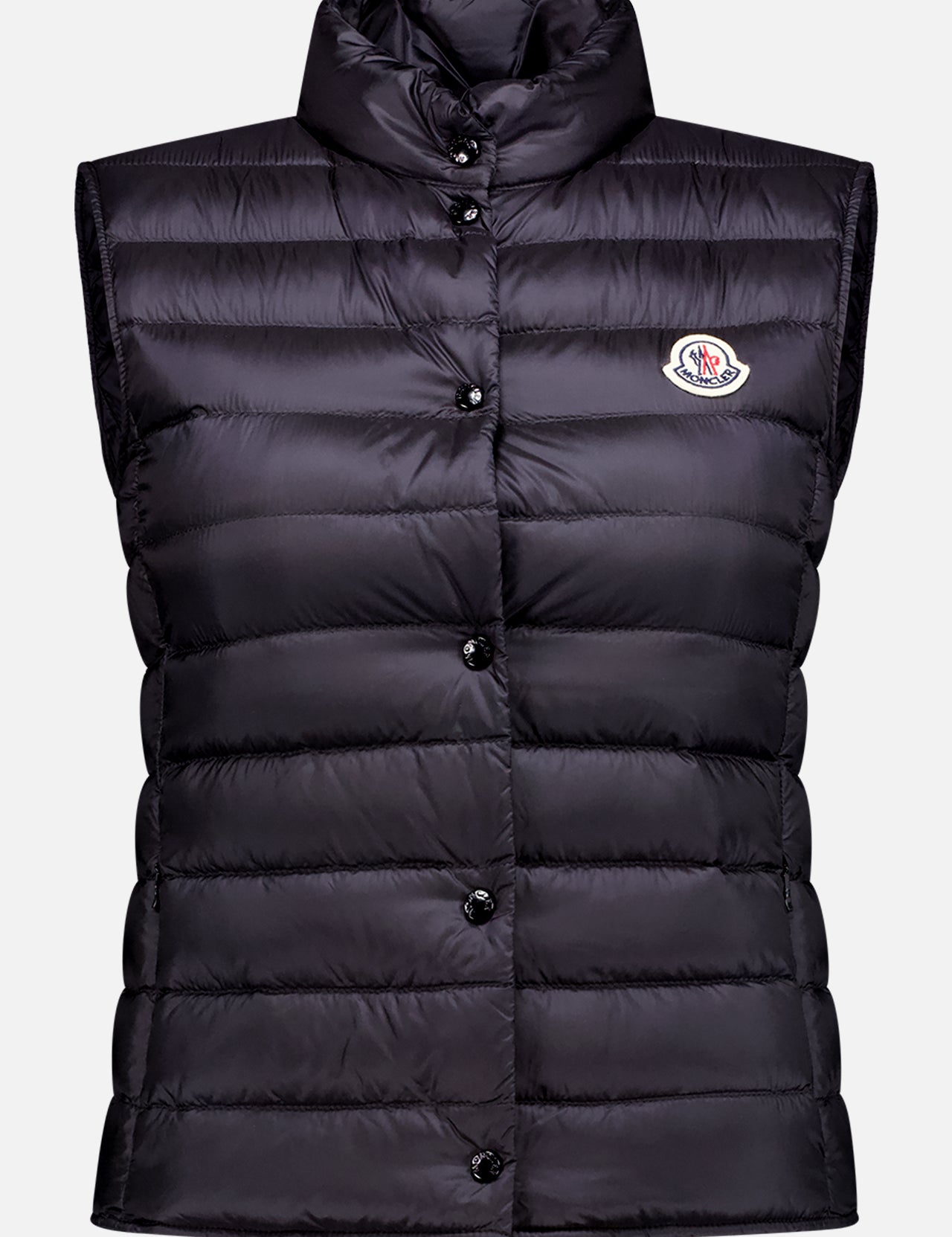 The MONCLER Liane Puffer Vest is a sleeveless, black vest with a high collar, button closure, and a logo patch on the left chest—perfect lightweight outerwear for layering.