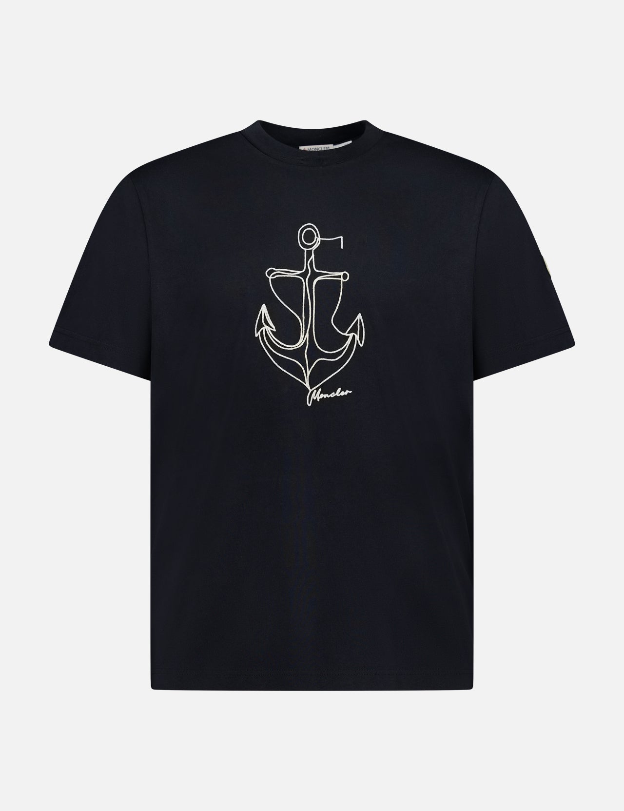 The MONCLER Anchor Graphic Short Sleeve T-shirt features a black design with a minimalist white anchor graphic and "freedom" text on the front.