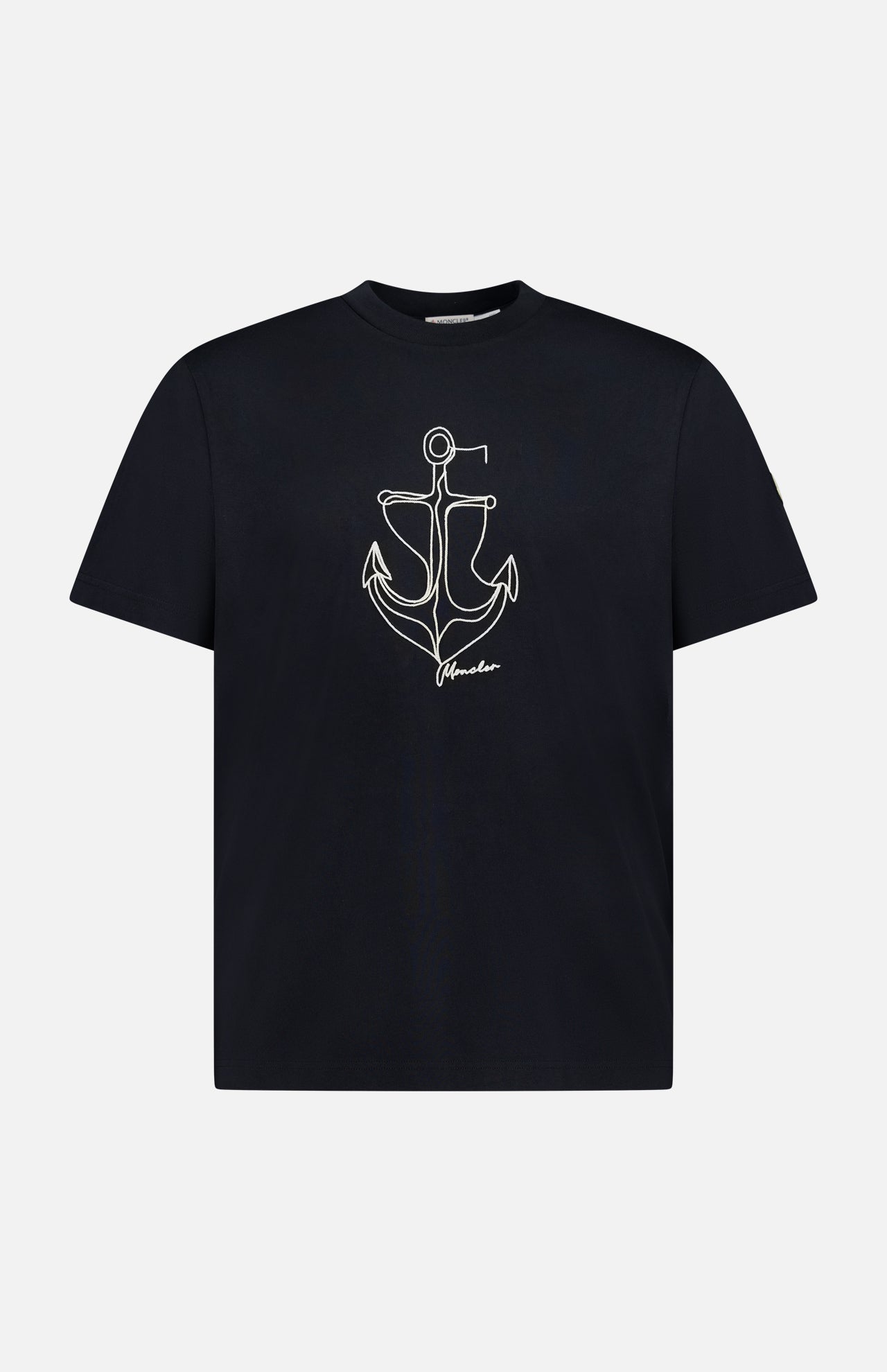 The MONCLER Anchor Graphic Short Sleeve T-shirt features a black design with a minimalist white anchor graphic and "freedom" text on the front.