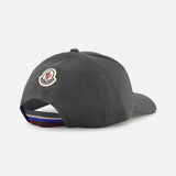 A dark grey MONCLER Monogram Baseball Cap seen from the back, featuring an embroidered logo above an adjustable strap with a blue, white, and red stripe—ideal for designer style fans.