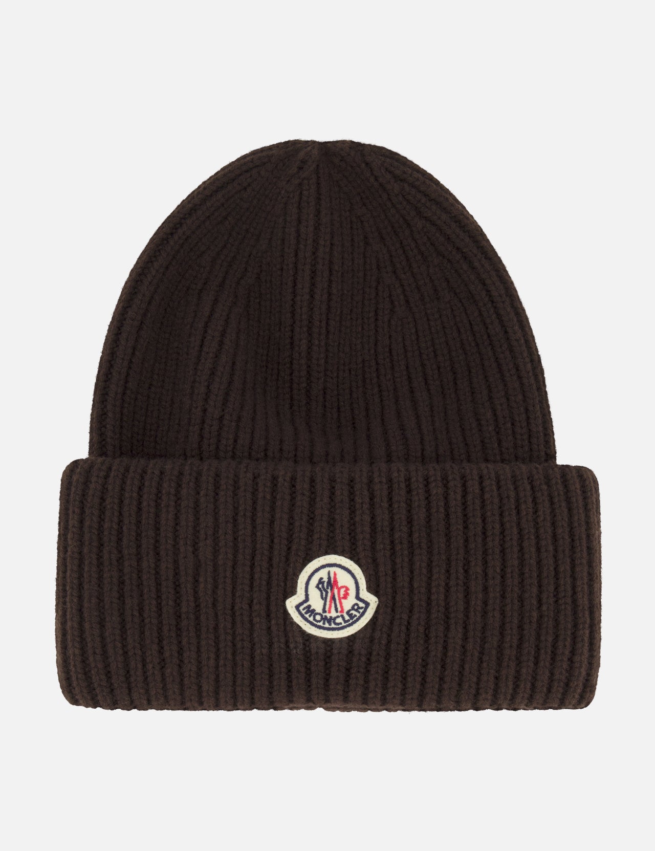 A dark brown MONCLER Contrast Logo Beanie crafted from virgin wool in a ribbed design, featuring a folded brim and a small contrast Moncler logo patch at the front center.