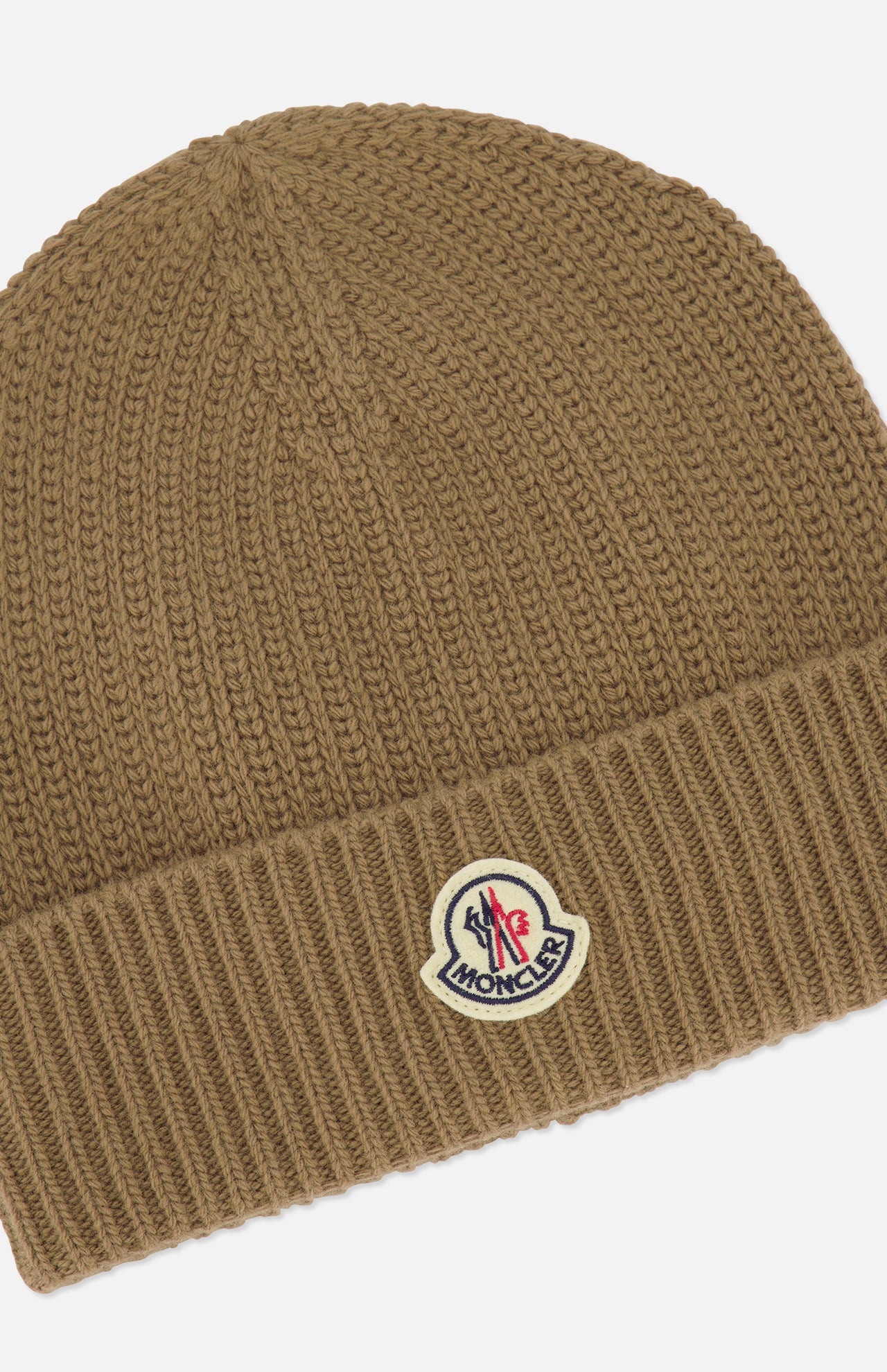 A brown MONCLER Ribbed Logo Beanie featuring a ribbed fold-over cuff and a prominent logo patch on the front.