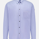 The MONCLER Cotton Button Up Shirt is a light blue, long-sleeve cotton shirt with a single chest pocket and buttoned collar, shown on a white background.
