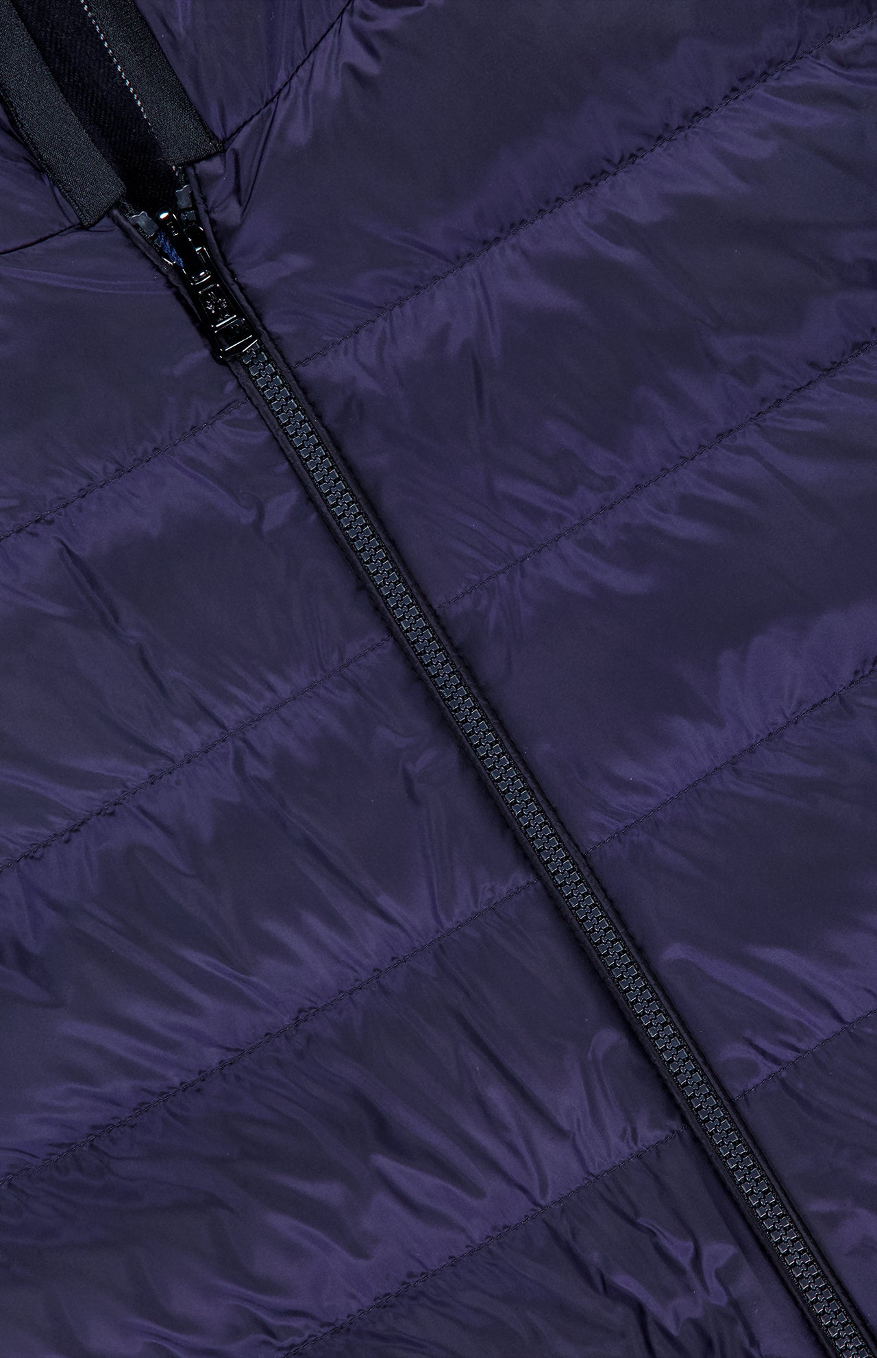Close-up of the MONCLER Ceze Striped Reversible Jacket in dark purple, showcasing a diagonal black zipper and horizontal stitching on the fabric.