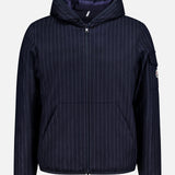 The MONCLER Ceze Striped Reversible Jacket features navy and white vertical pinstripes, a hood, front zipper closure, side pockets, and a zippered sleeve pocket, shown on a plain white background.