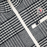 Close-up of the MONCLER Gienah Houndstooth Reversible Vest, featuring a houndstooth wool-blend, white zipper, Moncler logo patch on the chest, and a small zippered pocket.