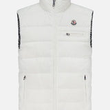 The MONCLER Gienah Houndstooth Reversible Vest is a white down-insulated vest with a high collar, front zipper, zippered chest and side pockets, a small chest logo, and a black-and-white checkered inner lining.