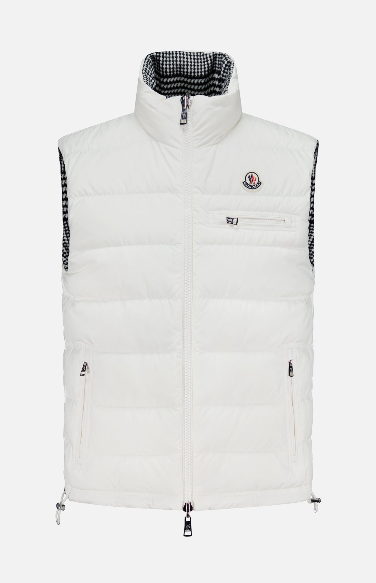 The MONCLER Gienah Houndstooth Reversible Vest is a white down-insulated vest with a high collar, front zipper, zippered chest and side pockets, a small chest logo, and a black-and-white checkered inner lining.