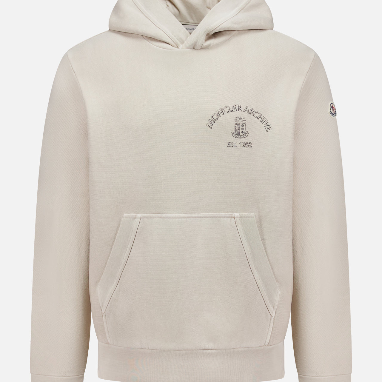 The MONCLER Hoodie Logo Sweatshirt is a beige pullover with a hood, front pocket, Archive text and emblem on the chest, and signature logo patch detailing on the left sleeve.