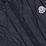 Close-up of a black MONCLER Reversible Paisley Fleece Vest featuring a visible zipper and a round Moncler logo patch on the right side. The fabric has a slight sheen with diamond-patterned stitching, accentuating the signature craftsmanship of this reversible vest.