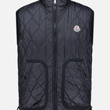 Introducing the MONCLER Reversible Paisley Fleece Vest: a black quilted sleeveless vest featuring a stylish front zipper, two spacious front pockets, and a small circular logo on the left chest. Designed with a high collar and an adjustable drawstring at the hem, this versatile piece draws inspiration from the iconic Moncler padded vest while showcasing reversible paisley fleece for modern flair.