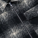 Close-up of the MONCLER Plaid Two-way Zip Overshirt, featuring a black and white plaid pattern, visible zipper, buttoned chest pocket, and the MONCLER label near the collar. The textured, slightly fuzzy fabric enhances this men’s casual outerwear piece with effortless style.