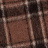Close-up of a soft, textured surface on the MONCLER Plaid Fringed Scarf, featuring intersecting lines in brown, black, and beige that create a classic checkered pattern from its luxurious alpaca-blend wool fabric.