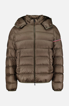 The Ravenlock Removable Hood Puffer Jacket by MONCLER is a brown down jacket featuring a hood, front zipper closure, horizontal quilting, and a subtle red and white stripe detail on the upper left sleeve. Crafted from lightweight nylon for comfort and versatility.