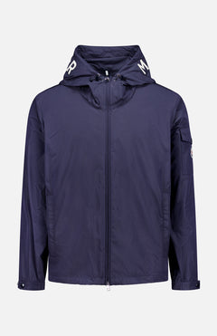 The MONCLER Sassiere Logo Hood Jacket is a navy blue jacket with a front zipper, long sleeves, and a small left sleeve pocket. The hood features white lettering on each side. Shown against a plain white background.
