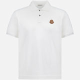 A MONCLER Short Sleeve Cotton Polo Shirt in plain white, featuring a collar, two buttons, and a small brown circular logo on the left chest.