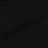 Close-up of the MONCLER Short Sleeve Logo T-Shirt in black, showcasing a subtle 3D embroidered logo and text on the chest for a textured look.