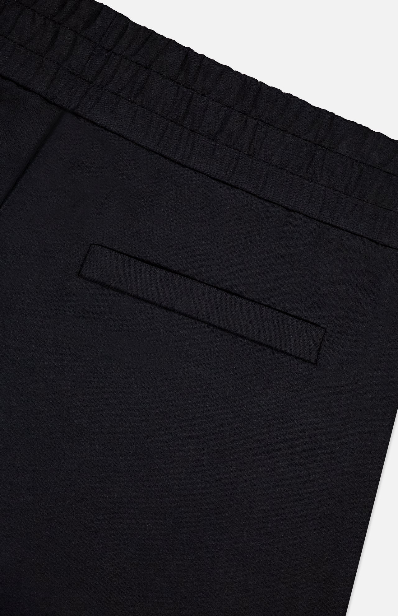 Close-up of MONCLER Zip Pocket Drawstring Shorts in black, made from double face cotton, featuring an elastic waistband and a single zip back pocket, photographed against a plain white background.