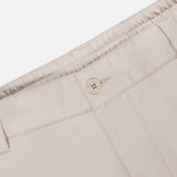 Close-up of the waistband of MONCLER Drawstring Stretch Cotton Trousers in light beige, featuring an elasticated back, drawstring fastening, and stitched belt loops.
