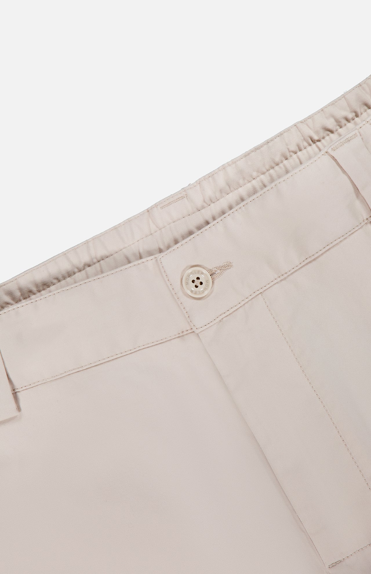 Close-up of the waistband of MONCLER Drawstring Stretch Cotton Trousers in light beige, featuring an elasticated back, drawstring fastening, and stitched belt loops.