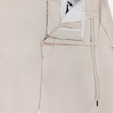 MONCLER Drawstring Stretch Cotton Trousers in beige feature an elastic waistband, belt loops, button closure, zip fly, and visible white drawstring with a partially unzipped front revealing the inner waistband and pocket lining.