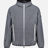 The MONCLER Vandelli Reversible Plaid Jacket is a black and white checkered hooded zip-front jacket featuring a front zipper, two side pockets, and elastic cuffs and hem for comfort. This lightweight outerwear option showcases a casual design with the versatility of reversibility.
