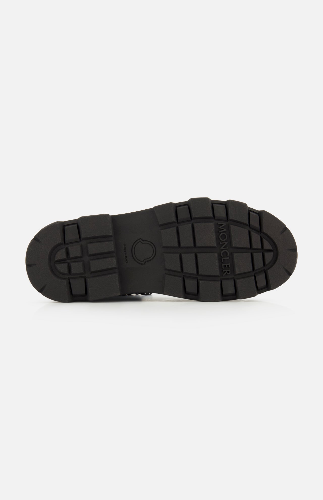 Black rubber sole with a rugged tread pattern, designed for Vera Sheal Ankle Boots by MONCLER. The sole features the MONCLER logo embossed in the center and the brand name near the top right side. Ideal for city living boots, it is shown against a plain white background.