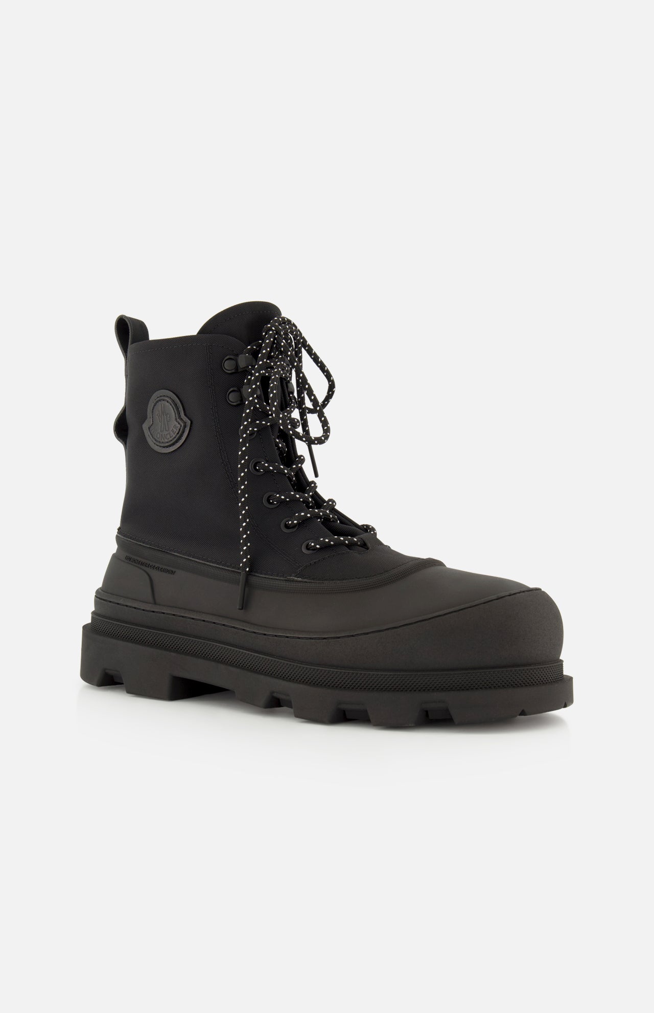 The Vera Sheal Ankle Boots by MONCLER feature a black lace-up design with a chunky sole, side logo patch, fleece interior, and patterned laces, shown against a plain white background.