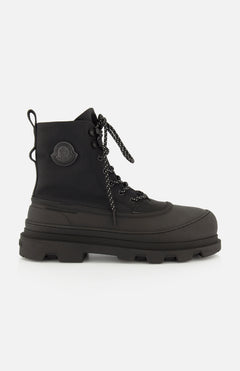These Vera Sheal Ankle Boots by MONCLER feature black lace-up combat styling with a thick, chunky sole, a round toe, and the signature Moncler logo patch on the ankle. With a cozy fleece interior, these boots are the perfect blend of comfort and style for city living.
