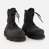 A pair of MONCLER Vera Sheal Ankle Boots in black, featuring thick rubber soles, speckled laces, and a cozy fleece interior, displayed on a white background—perfect for city living boot style.