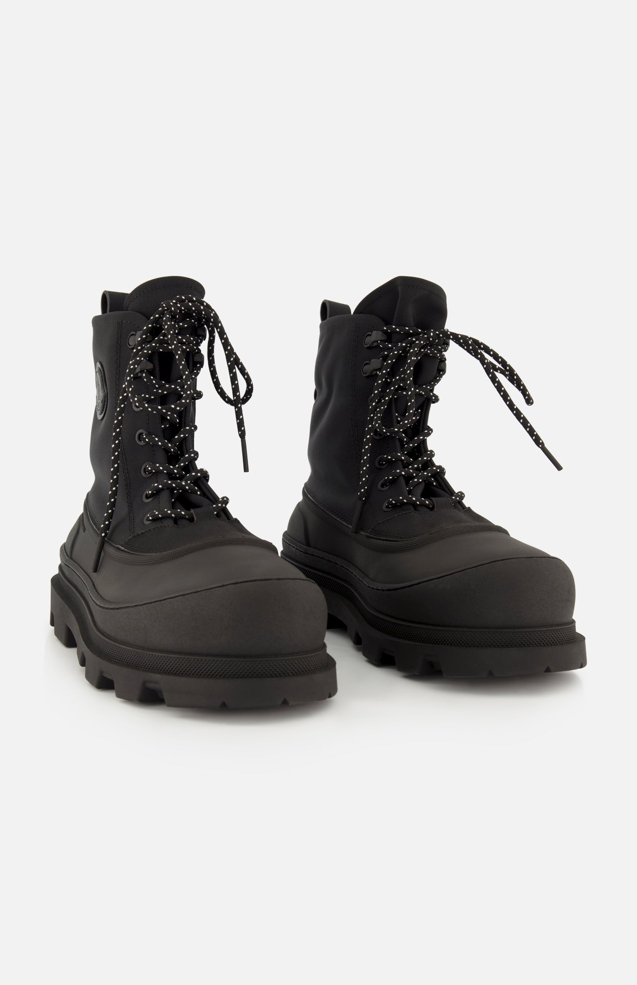 A pair of MONCLER Vera Sheal Ankle Boots in black, featuring thick rubber soles, speckled laces, and a cozy fleece interior, displayed on a white background—perfect for city living boot style.