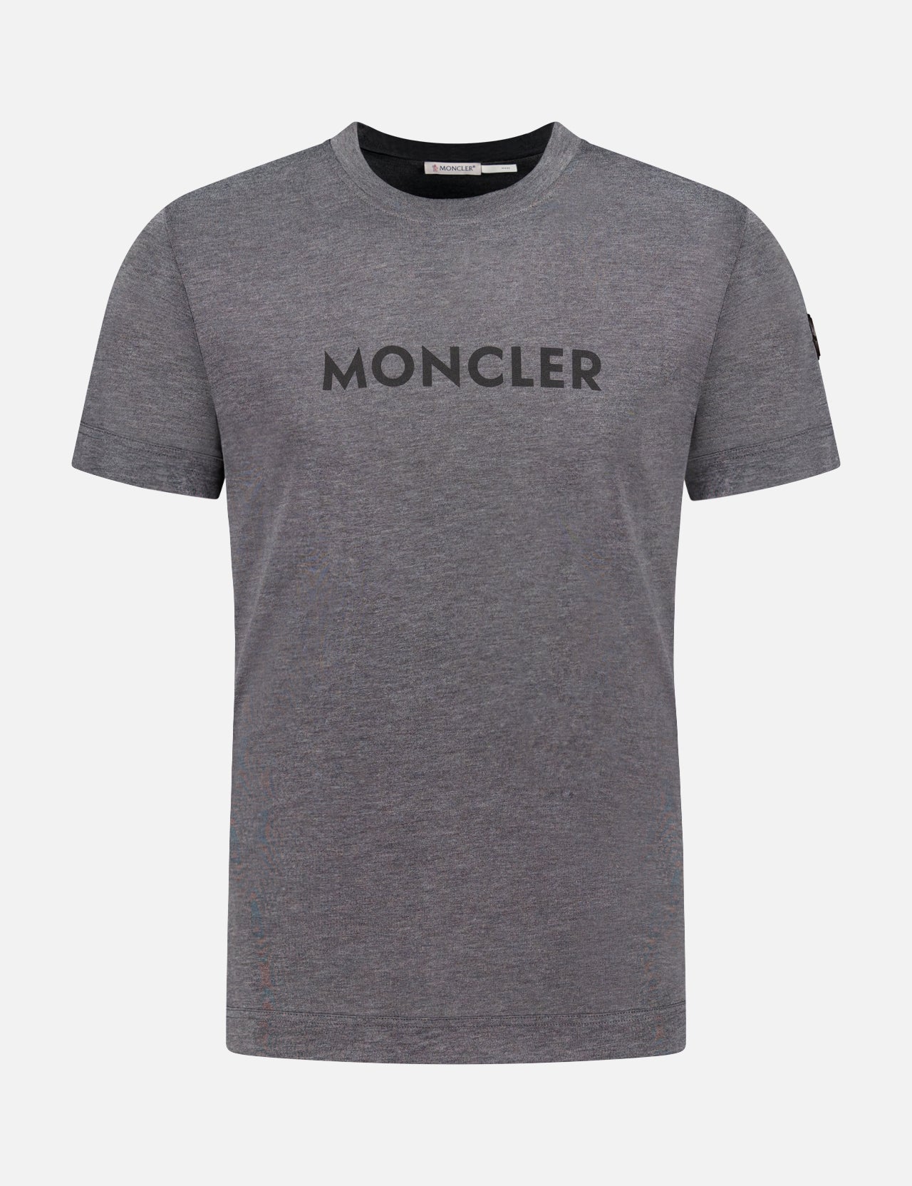The MONCLER Short Sleeve Logo T-Shirt features a plain grey design with a bold black MONCLER logo across the chest, shown against a white background.