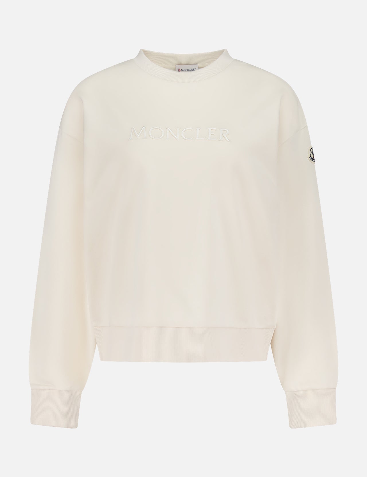 The Moncler Cotton Logo Sweatshirt is an off-white crew neck with long sleeves, subtle front embossing, and a signature logo patch—bringing iconic après-ski flair to classic luxury style.