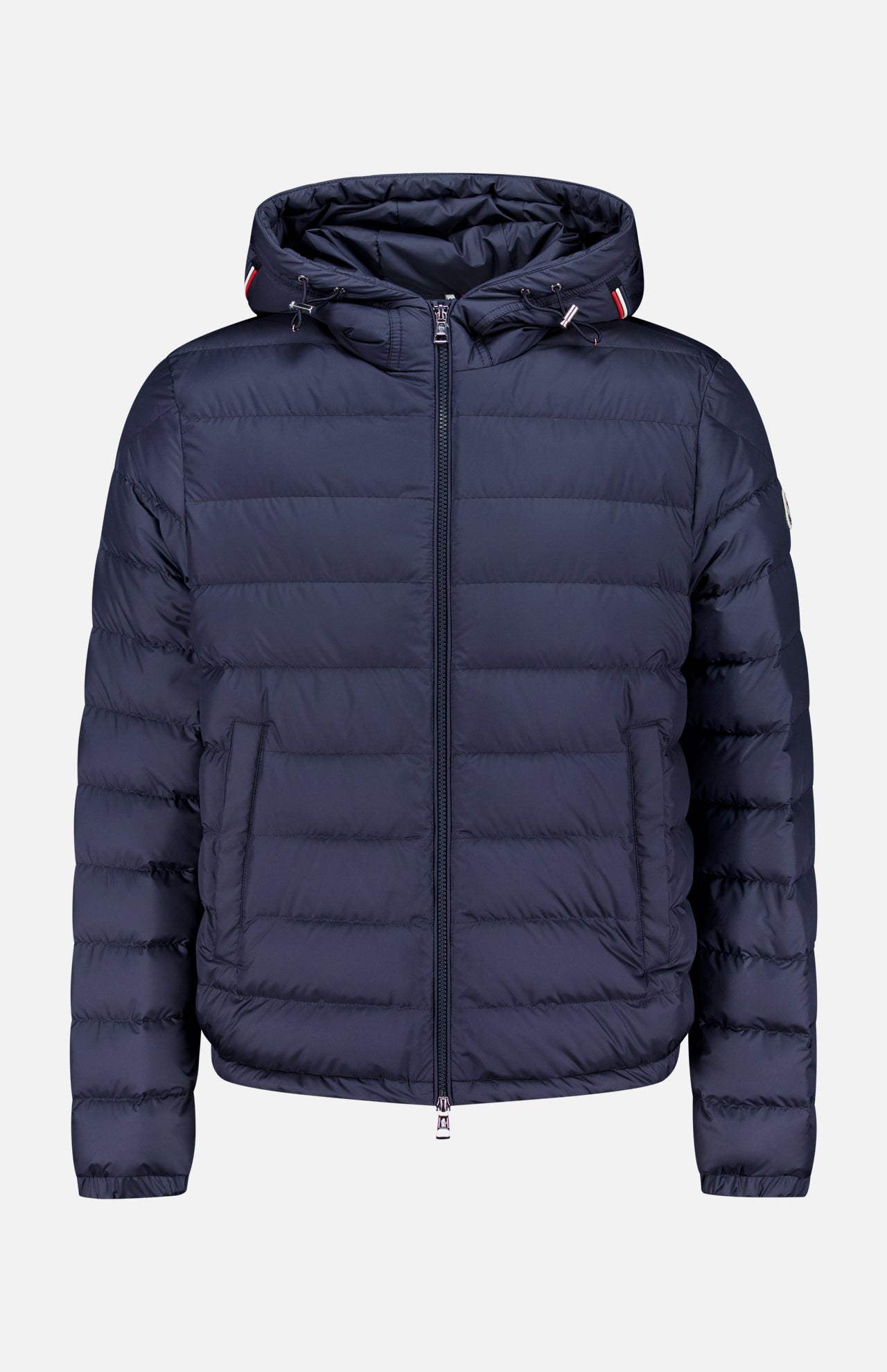 The MONCLER Vermeille Hooded Puffer Jacket, in navy blue with quilting, front zipper, hood, and two side pockets, is stylishly displayed on a plain light gray background.