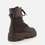 The MONCLER Aurea Quilted Ankle Boots feature dark brown leather and nylon quilted panels, a chunky treaded sole, pull tab at the heel, and embossed logos for a utility-inspired look.