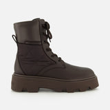 The MONCLER Aurea Quilted Ankle Boots feature dark brown leather and nylon, lace-up front, chunky sole, and quilted side panels for a utility-inspired look, shown against a plain white background.